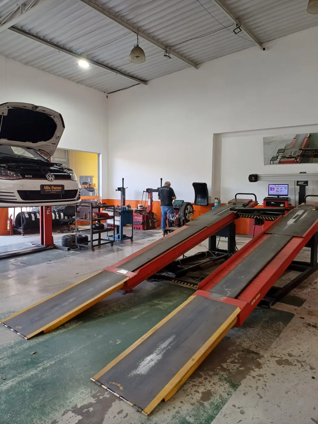 Salão da Mix Pneus com a rampa de alinhamento 3D e carro no elevador
